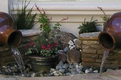 Custom water feature with two pots flowing into a dry pond